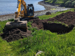 A digger preparing the ground for a septic tank installation
