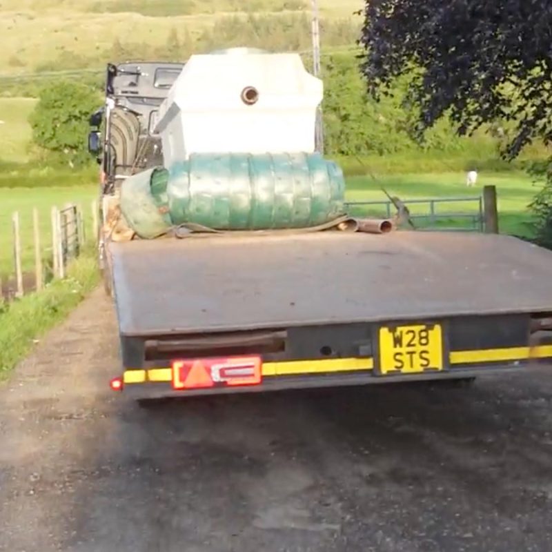 New sewage treatment tank on a truck going down a windy road.