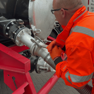 A pipe being attached to the back of a Septic Tank Services Ltd lorry ready for emptying a septic tank