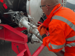A pipe being attached to the back of a Septic Tank Services Ltd lorry ready for emptying a septic tank
